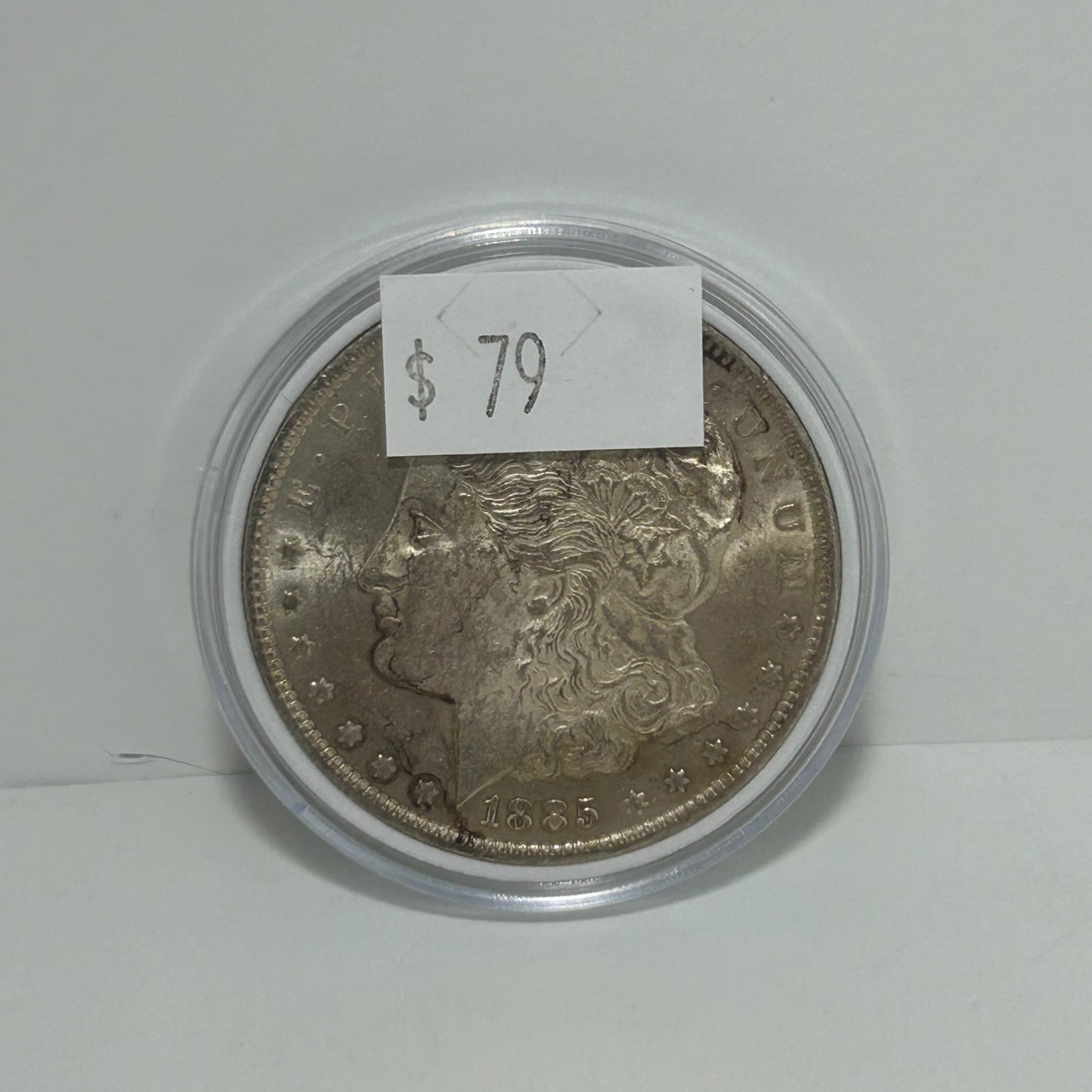 1885 Morgan Silver Dollar in circular protector